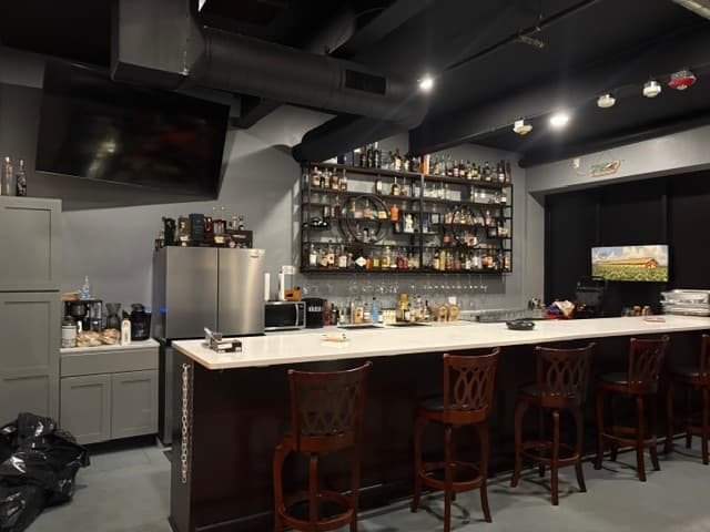 Bar area close-up with wooden stools and bottle display