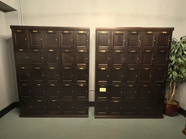 Dark wood cigar lockers with brass name plates
